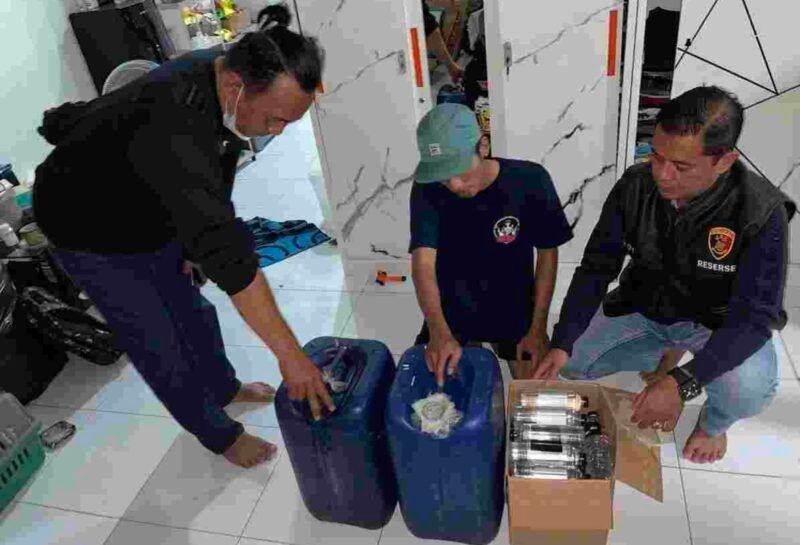 Petugas saat mengamankan minuman keras ilegal yang beredar di wilayah hukum Polres Malang
